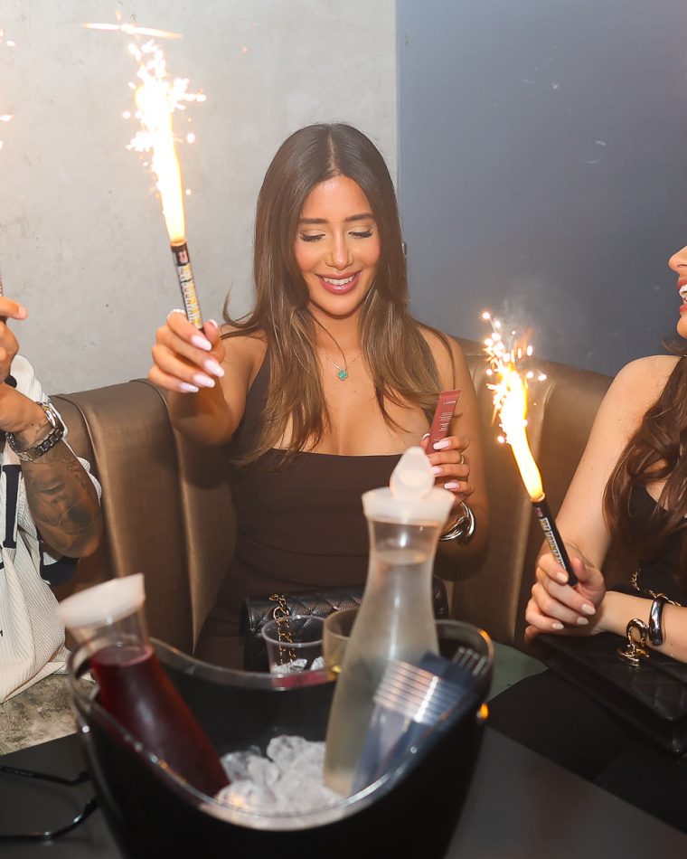 A bottle on ice and sparklers at a booth table at Cabo.