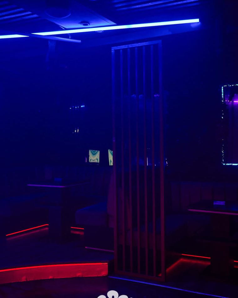 Booth seating at Cabo lit in deep blue with red trim along the banquettes.