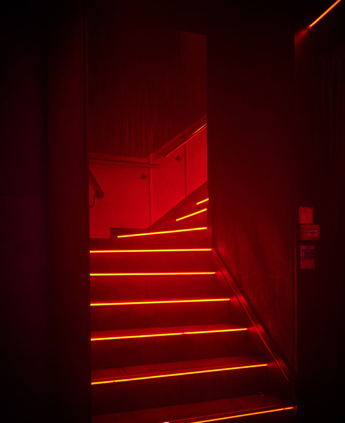 The staircase down into Cabo, each step edged in red light.
