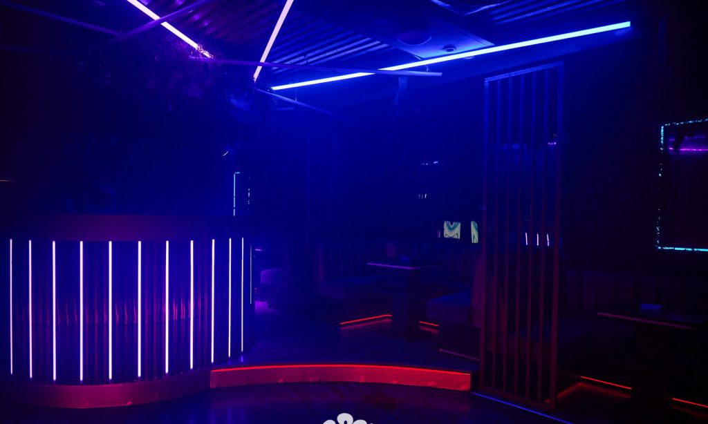 The main room at Cabo before service, lit in blue and red neon.