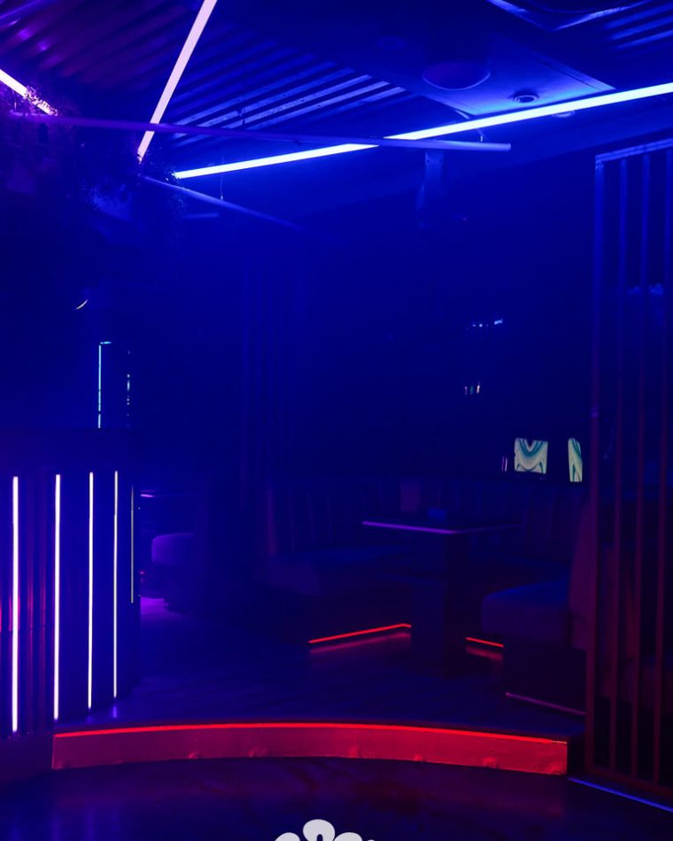The main room at Cabo before service, lit in blue and red neon.